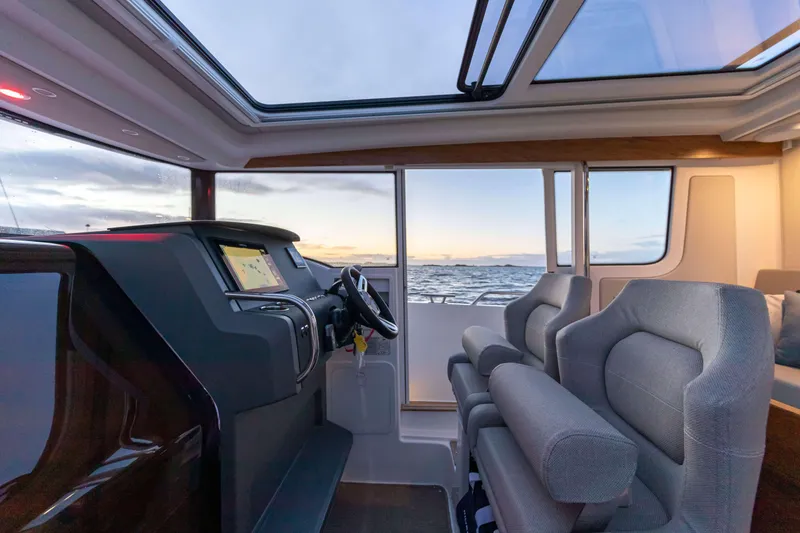 Slide: The Image of Interior of 2025 Nimbus Commuter 9 boat with modern dashboard and ocean view. - 6
