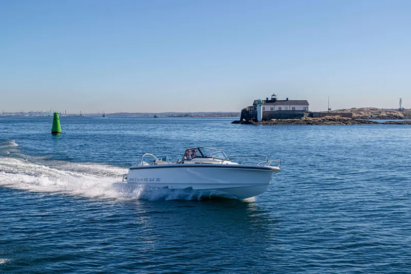 Slide: The Image of Nimbus Tender 8 boat cruising near a coastal building, 2025 model. - 12