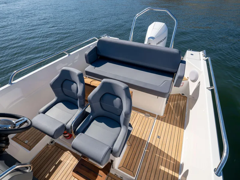 Slide: The Image of 2025 Nimbus Tender 8 boat interior with gray seating and wooden deck. - 19
