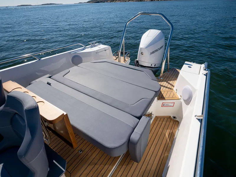 Slide: The Image of Nimbus Tender 8 (2025) boat with spacious deck and Mercury outboard motor on calm water. - 21