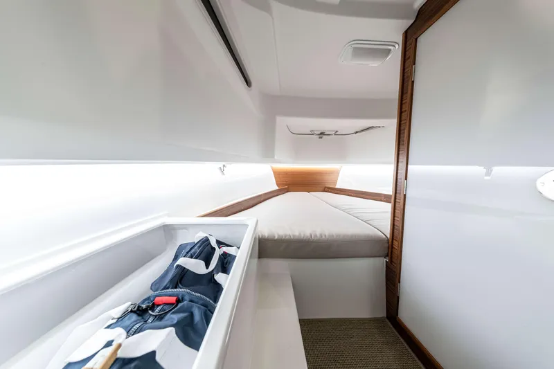 Slide: The Image of Interior cabin of 2025 Nimbus Tender 8, featuring a cozy bed and storage space. - 24