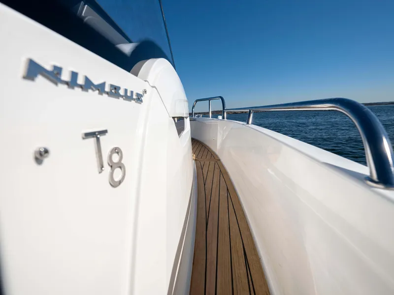 Slide: The Image of Nimbus Tender 8 boat, 2025 model, sleek design, wooden deck, stainless steel railings, ocean backdrop. - 26
