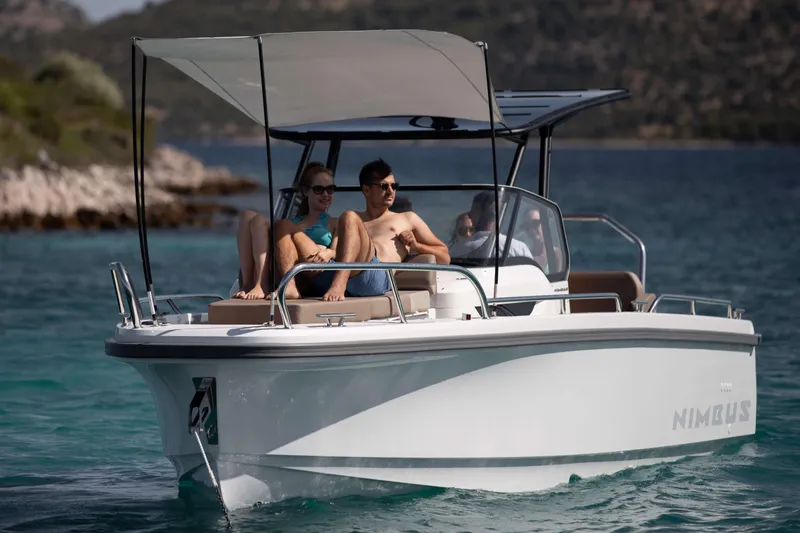 Slide: The Image of 2025 Nimbus Tender 8 boat cruising on clear water with passengers relaxing. - 31