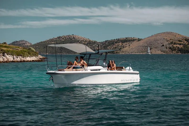 Slide: The Image of 2025 Nimbus Tender 8 boat cruising on a serene lake with scenic hills in the background. - 5