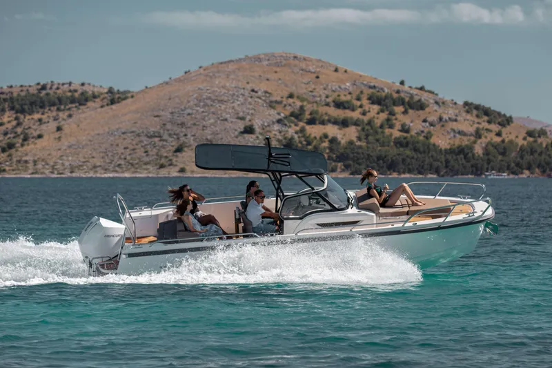 Slide: The Image of 2025 Nimbus Tender 8 boat cruising on clear water with passengers, scenic island backdrop. - 6