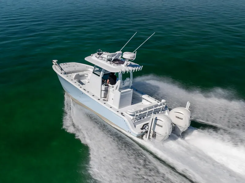 Slide: The Image of 2025 Freeman 28 boat cruising on clear green water, equipped with twin Yamaha engines. - 12