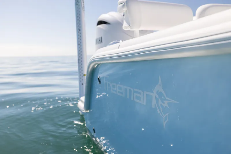 Slide: The Image of Freeman 28 boat on calm sea, 2025 model, side view with logo visible. - 19