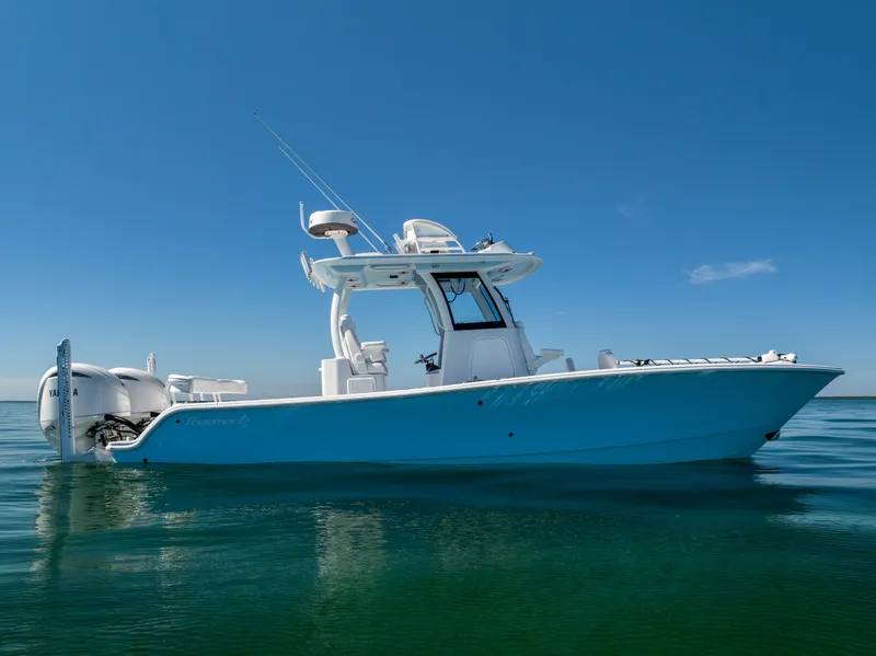 Slide: The Image of 2025 Freeman 28 boat on calm water under clear blue sky. - 2