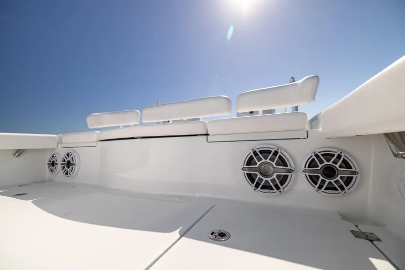 Slide: The Image of 2025 Freeman 28 boat interior with white seating and speakers under a clear blue sky. - 28