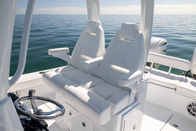 Slide: The Image of 2025 Freeman 28 boat interior with white seating and steering wheel on open water. - 34