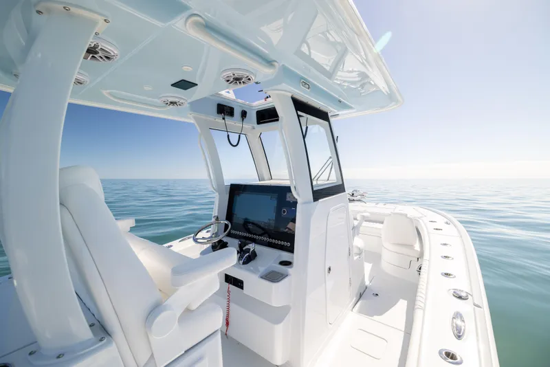 Slide: The Image of 2025 Freeman 28 boat interior with modern helm, on calm ocean waters. - 35