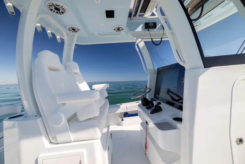 Slide: The Image of 2025 Freeman 28 boat interior with modern helm and seating, overlooking calm ocean waters. - 36