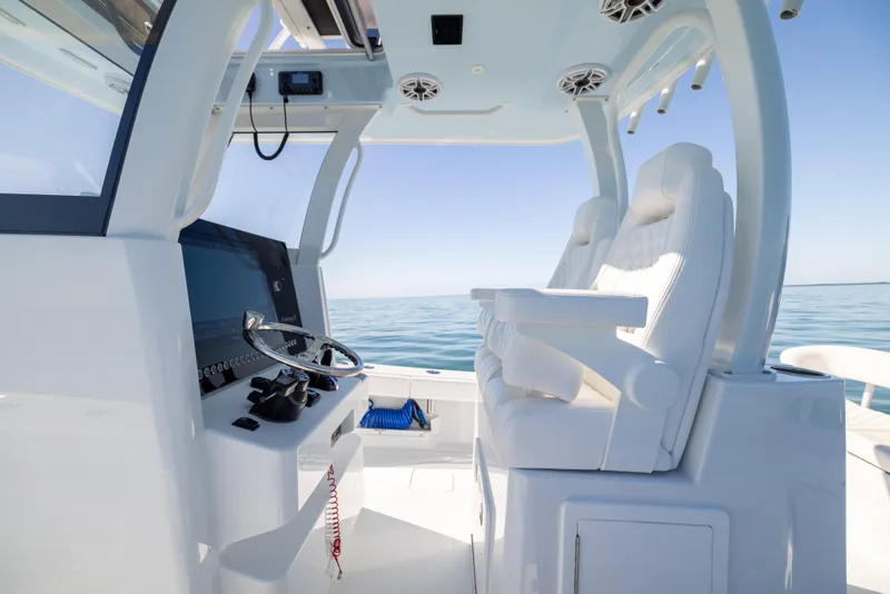 Slide: The Image of 2025 Freeman 28 boat interior with modern helm and seating, overlooking calm ocean waters. - 37