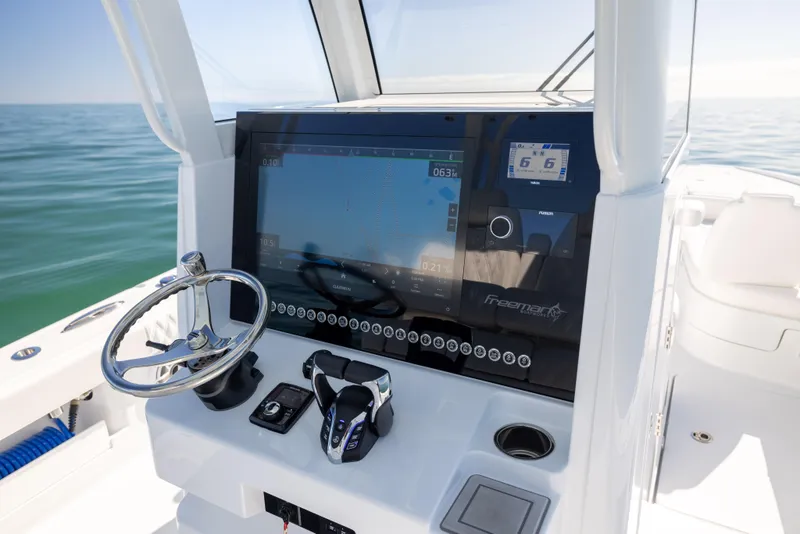 Slide: The Image of Freeman 28 boat dashboard with advanced navigation system, 2025 model, on open water. - 40