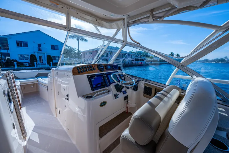 Slide: The Image of 2013 Grady-White 335 boat interior with helm, overlooking waterfront homes. - 18