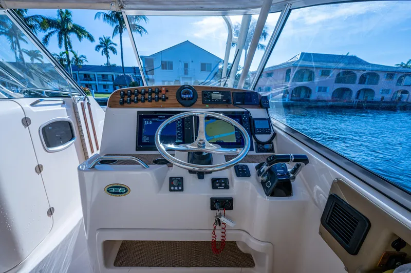 Slide: The Image of Helm of 2013 Grady-White 335 boat with navigation equipment, docked near waterfront homes. - 19