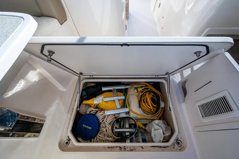 Slide: The Image of Storage compartment on a 2013 Grady-White 335 boat, containing ropes and safety equipment. - 25