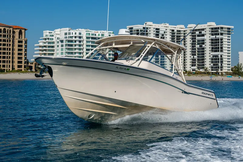 Slide: The Image of 2013 Grady-White 335 boat cruising near modern beachfront buildings. - 30