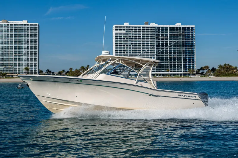 Slide: The Image of 2013 Grady-White 335 boat cruising near modern high-rise buildings. - 31