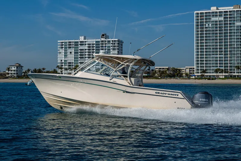 Slide: The Image of 2013 Grady-White 335 boat cruising on water near city skyline. - 33