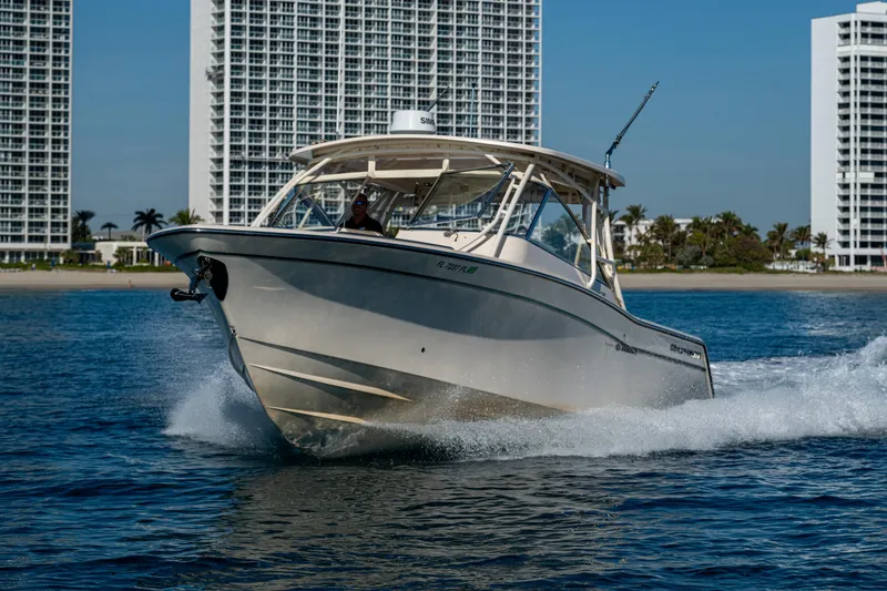 Slide: The Image of 2013 Grady-White 335 boat cruising on water near tall buildings. - 37