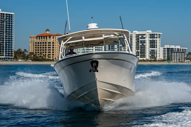 Slide: The Image of 2013 Grady-White 335 boat cruising on water with city skyline in background. - 39