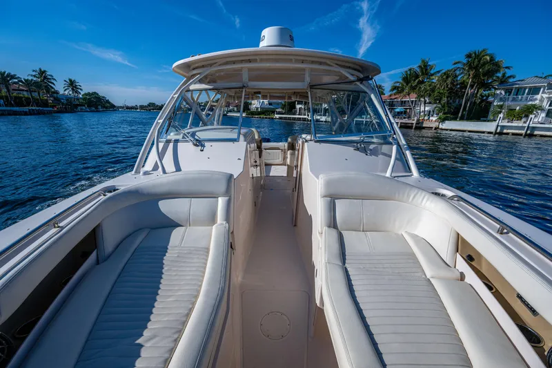 Slide: The Image of 2013 Grady-White 335 boat with spacious seating, docked by a scenic waterfront. - 4