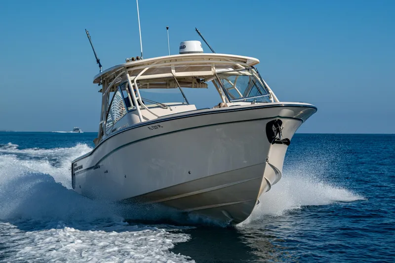 Slide: The Image of 2013 Grady-White 335 boat cruising on open water under clear blue sky. - 43
