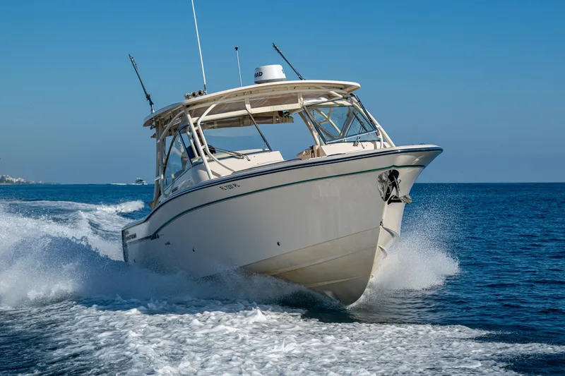 Slide: The Image of 2013 Grady-White 335 boat cruising on open water, creating a dynamic wake. - 44