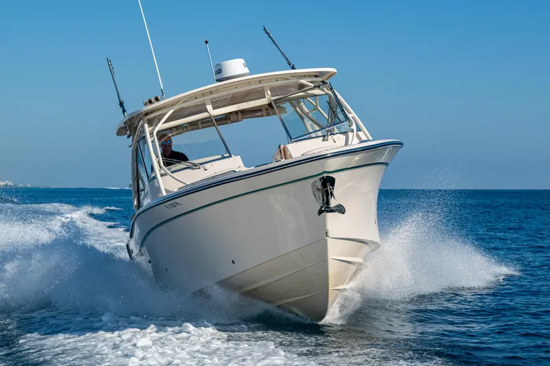 Slide: The Image of 2013 Grady-White 335 boat cruising on open water, creating splashes. - 45