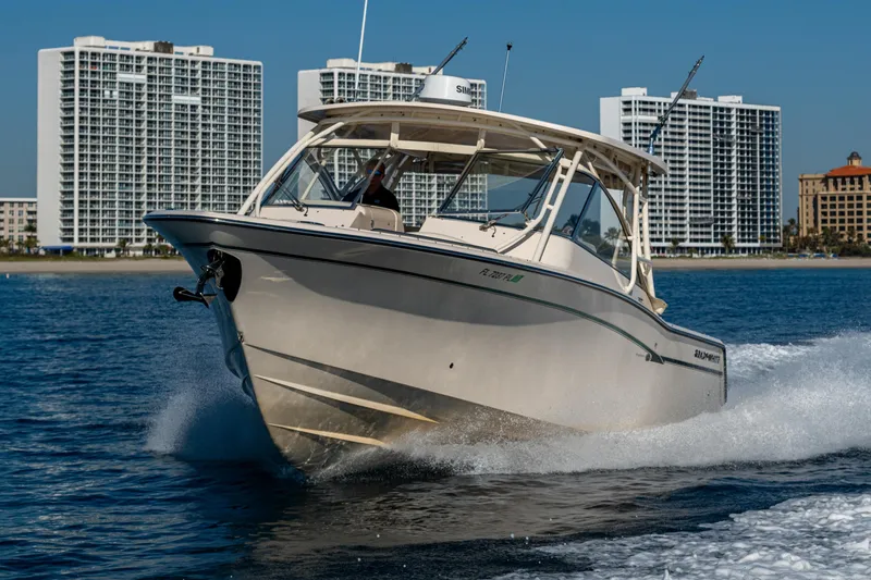 Slide: The Image of 2013 Grady-White 335 boat cruising on water with city skyline in background. - 48