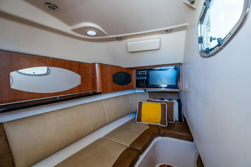 Slide: The Image of 2013 Grady-White 335 cabin interior with seating, cushions, and porthole window. - 7