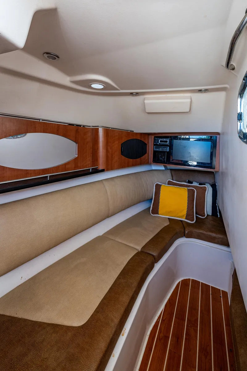 Slide: The Image of 2013 Grady-White 335 cabin interior with cushioned seating and wood accents. - 8