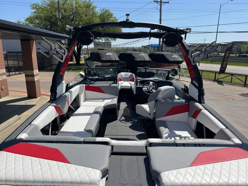 Slide: The Image of 2024 Tigé Z3 boat interior with red and white seating, parked outdoors. - 11