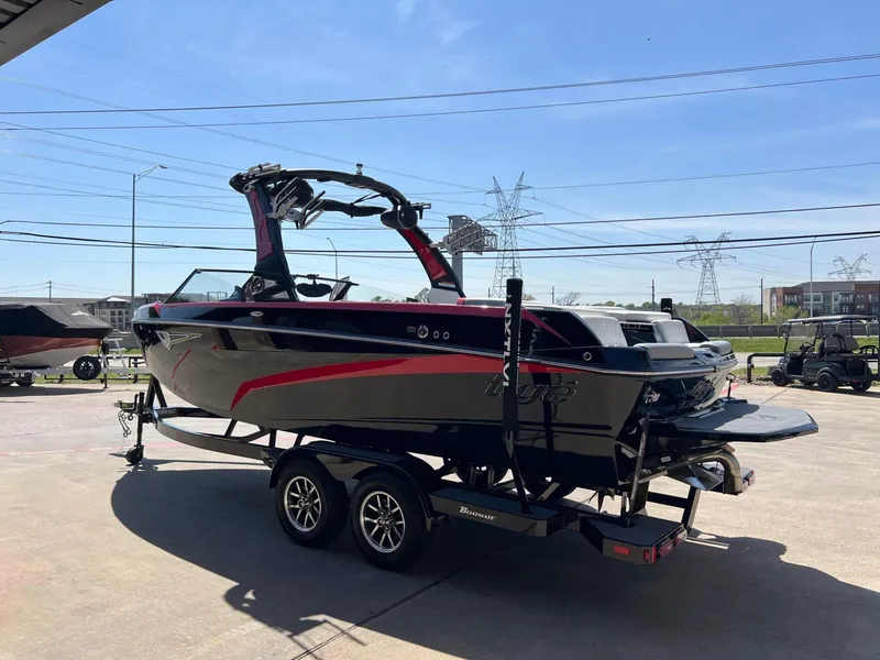 Slide: The Image of 2024 Tigé Z3 boat on trailer, black and red design, parked outdoors under clear sky. - 8