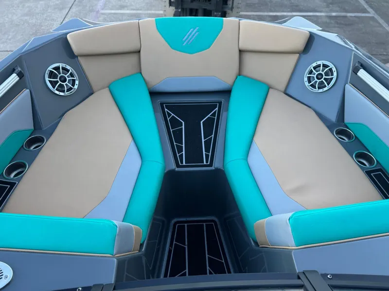 Slide: The Image of 2023 ATX Surf Boats 20 Type-S interior with teal and beige seating, cup holders, and speakers. - 6