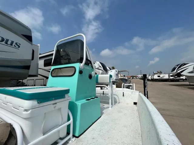 Slide: The Image of 2023 Freedom PATRIOT boat with turquoise console, parked among RVs under a clear sky. - 11