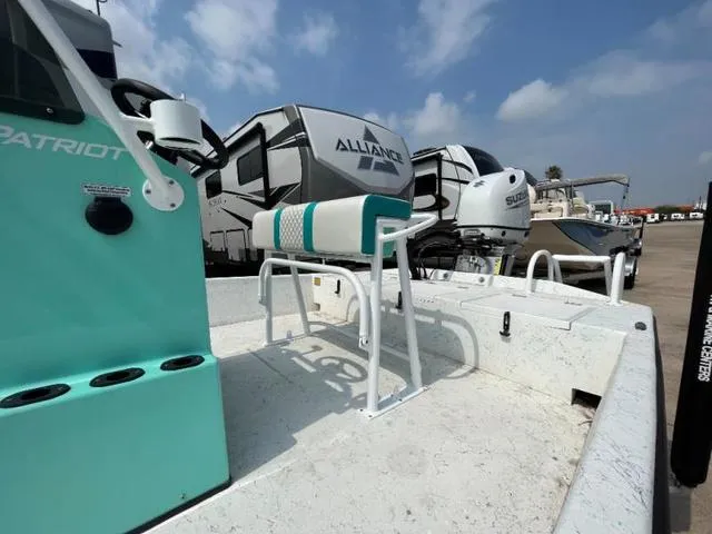 Slide: The Image of 2023 Freedom PATRIOT boat with teal accents, parked near RVs under a cloudy sky. - 12