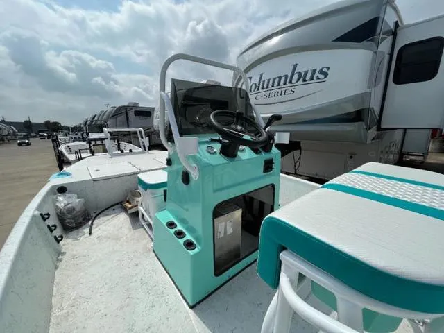 Slide: The Image of 2023 Freedom PATRIOT boat with teal console and seating, parked near RVs. - 13