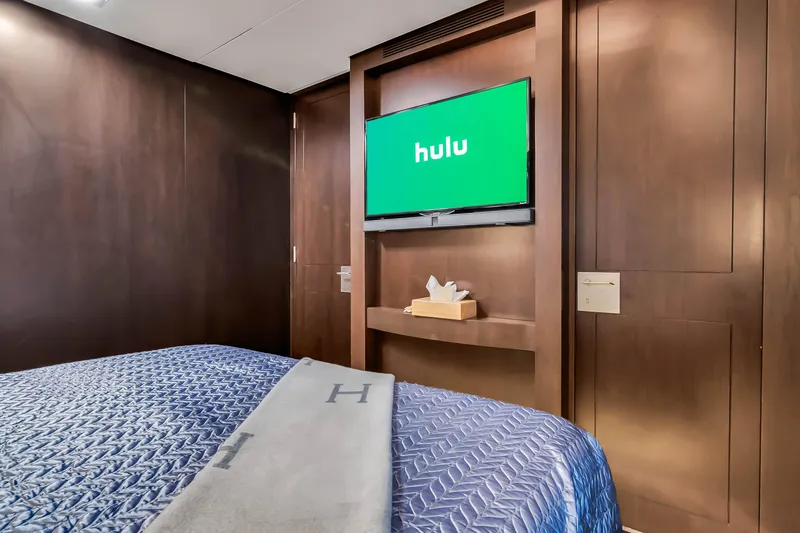 Slide: The Image of Luxurious Azimut 116 yacht bedroom with TV, 2012 model, featuring elegant wood paneling. - 48