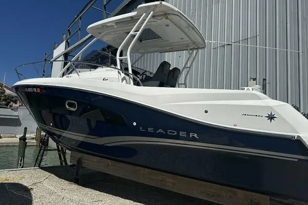 Slide: The Image of 2024 Jeanneau Leader 9.0 WA boat docked near a metal building. - 1