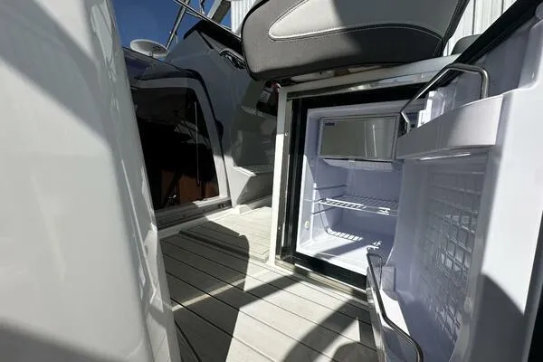 Slide: The Image of 2024 Jeanneau Leader 9.0 WA boat interior with open mini fridge on deck. - 45