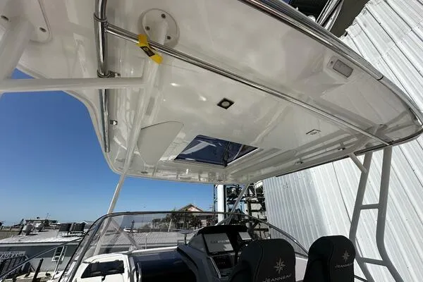 Slide: The Image of 2024 Jeanneau Leader 9.0 WA boat interior with helm and seating under a hardtop. - 48