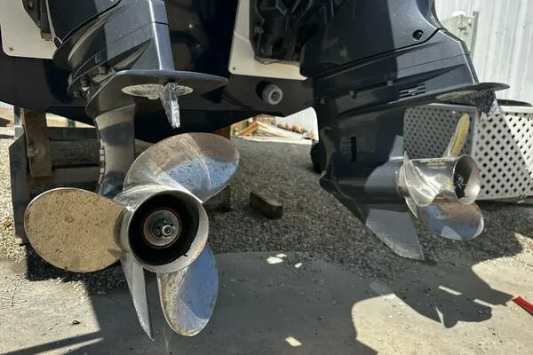 Slide: The Image of Twin propellers of a 2024 Jeanneau Leader 9.0 WA boat on a gravel surface. - 5