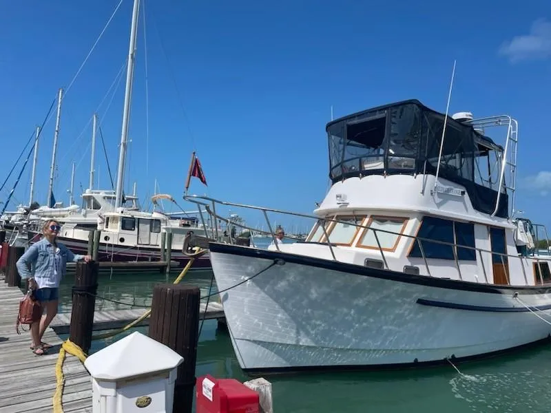 The Image of 1984 Monk 36 boat docked at marina under clear blue sky. - 0