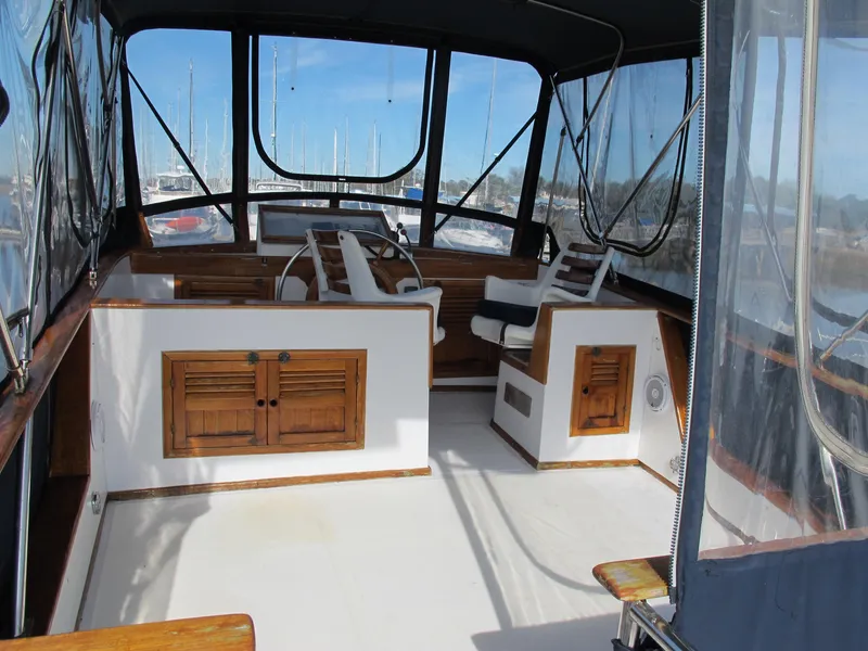 Slide: The Image of 1984 Monk 36 boat interior with helm, wooden cabinets, and seating. - 22