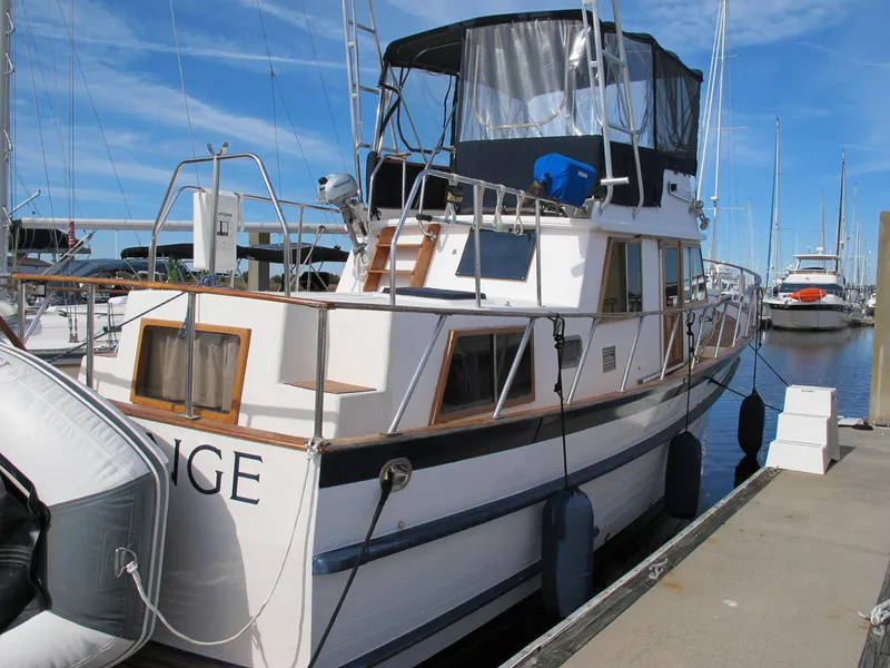 Slide: The Image of 1984 Monk 36 boat docked at marina, featuring classic design and spacious deck. - 3