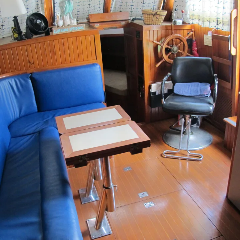 Slide: The Image of Interior of a 1984 Monk 36 boat with blue seating and wooden helm. - 31