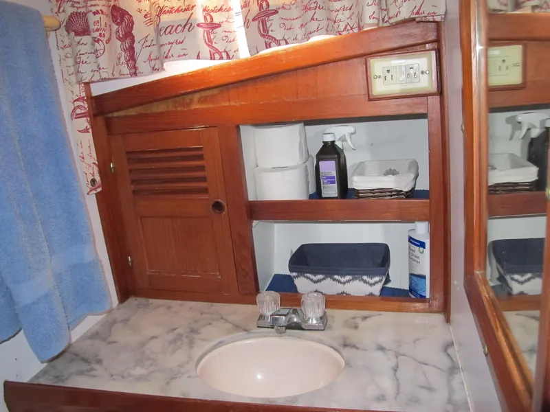 Slide: The Image of Vintage 1984 Monk 36 bathroom with marble sink, wooden cabinet, and nautical-themed decor. - 32