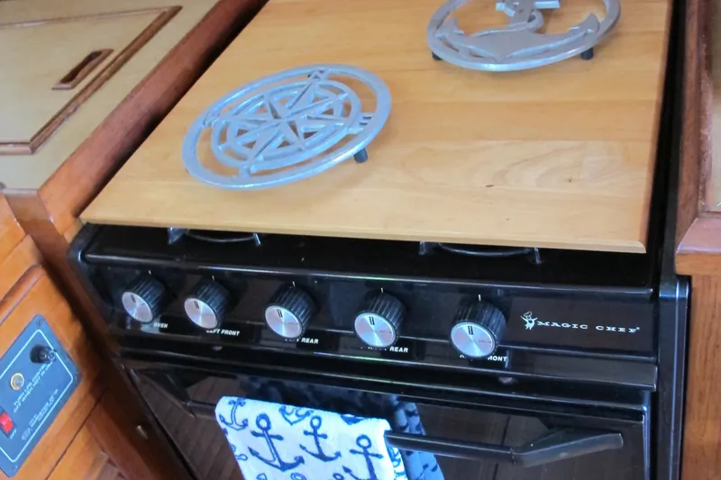 Slide: The Image of Vintage 1984 Monk 36 stove with nautical-themed towel and decorative trivets. - 45